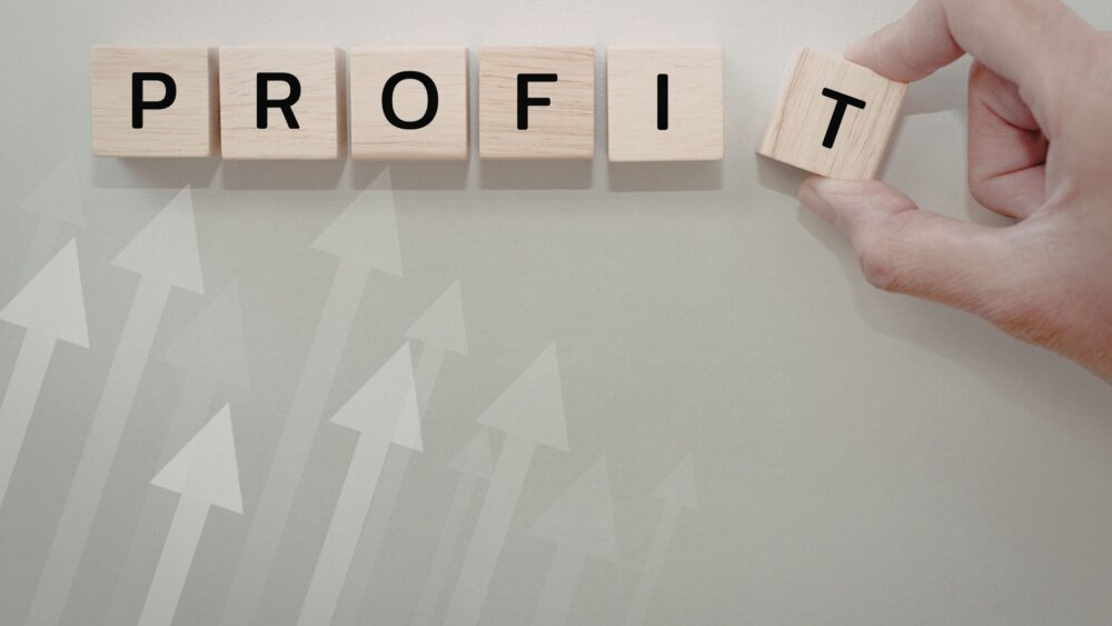 The word 'profit' spelled out in small wooden blocks printed with the letters.