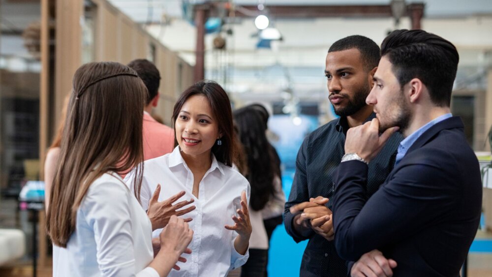A group of business people talk in a circle about finding the right person to join the team